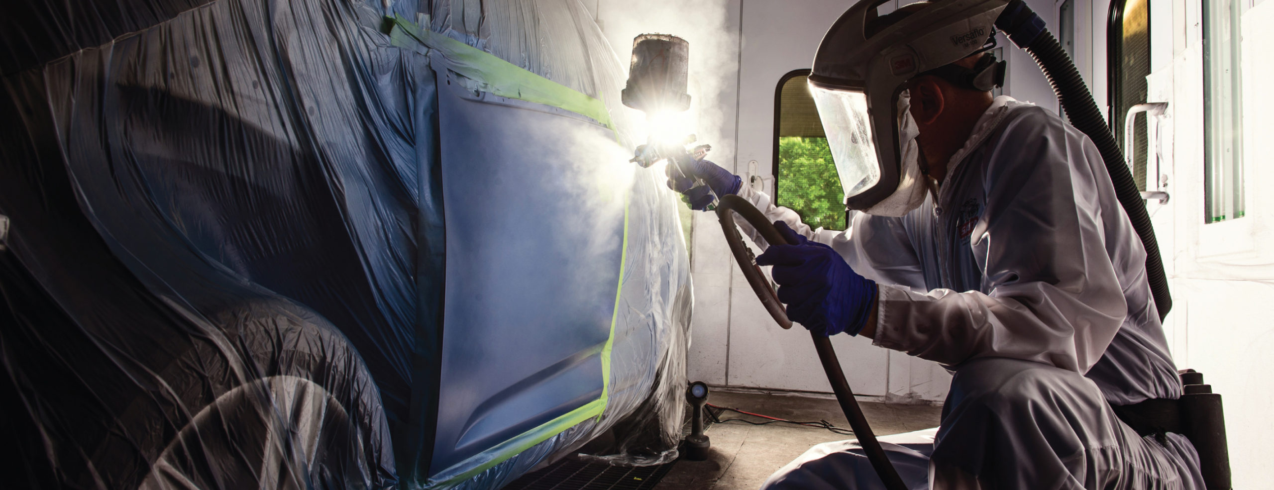 Painter using Accudraft TITAN Downdraft Paint Booth